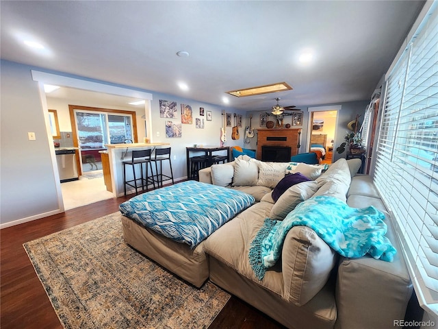 living room featuring ceiling fan, a fireplace, and hardwood / wood-style floors