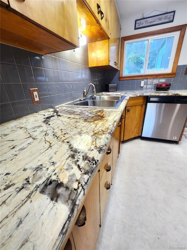 kitchen featuring light stone countertops, decorative backsplash, sink, and stainless steel dishwasher