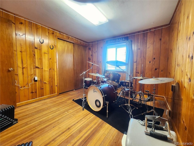 miscellaneous room with wood walls and light hardwood / wood-style flooring