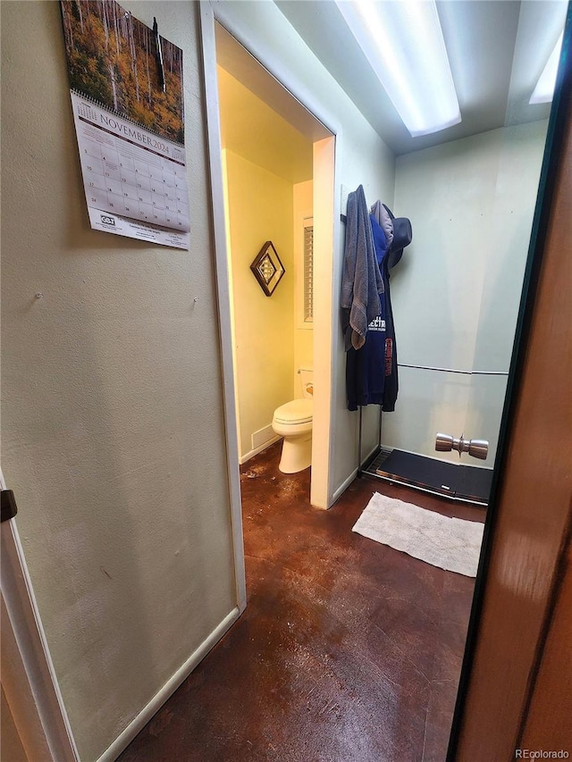 bathroom featuring toilet and concrete flooring