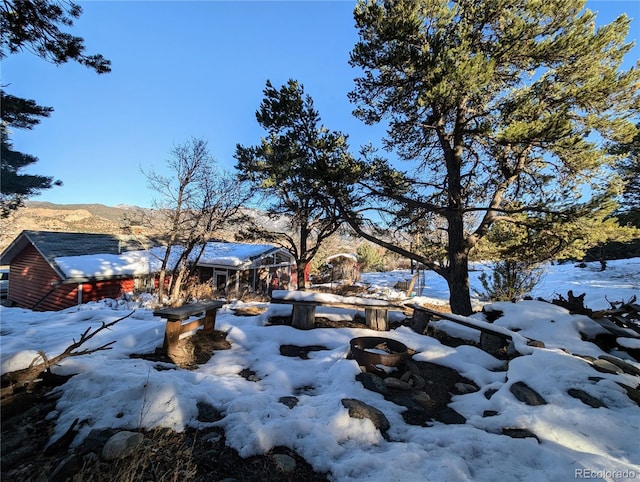 yard layered in snow featuring a mountain view