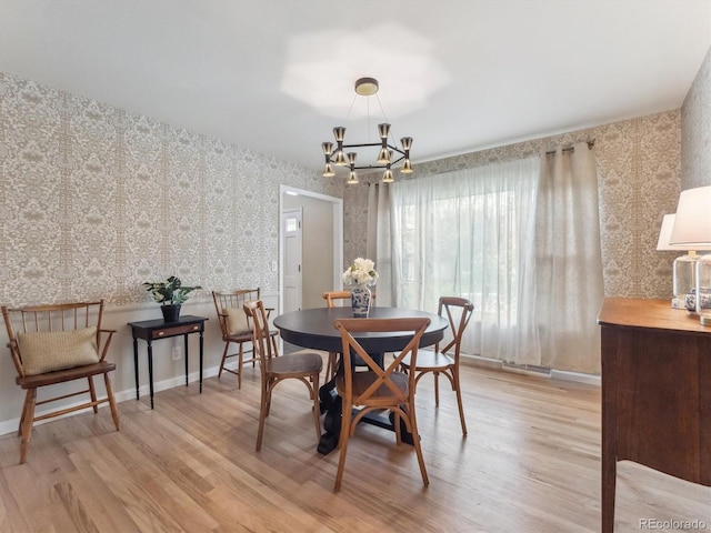 dining room with wallpapered walls, a chandelier, light wood-type flooring, and baseboards