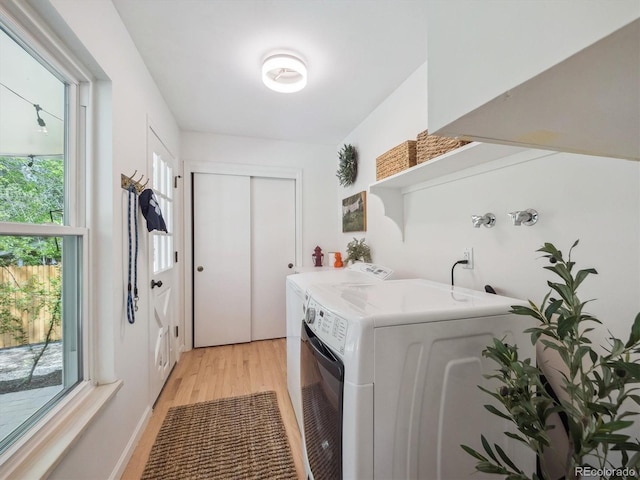 laundry room featuring light wood-style floors and separate washer and dryer