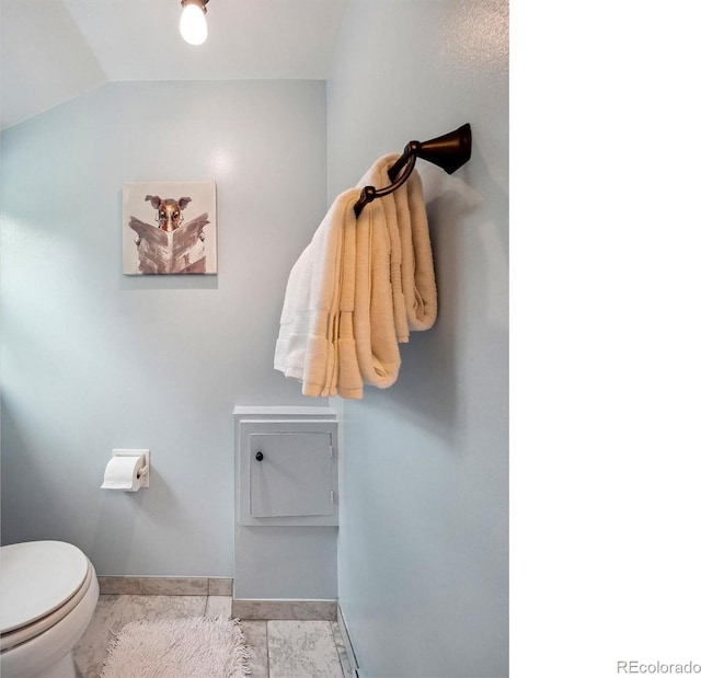 bathroom with toilet, vaulted ceiling, and baseboards