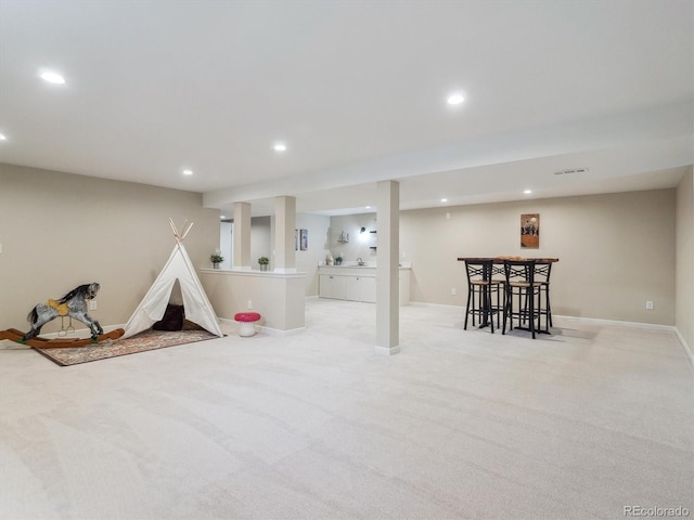 finished basement featuring recessed lighting, bar, light carpet, and baseboards