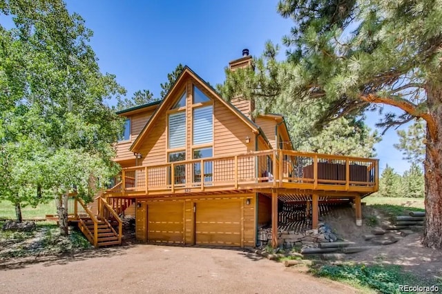 rear view of house featuring a deck and a garage