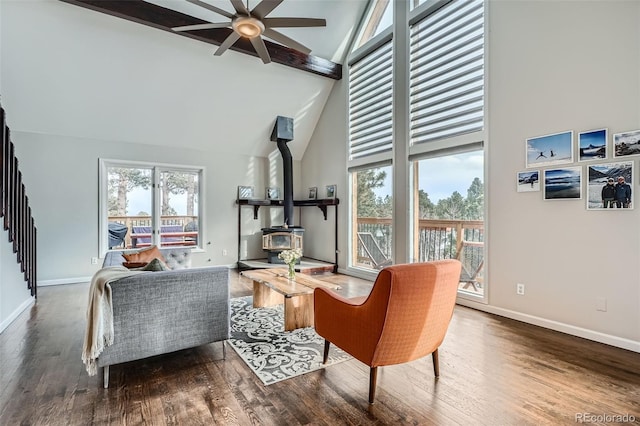 sitting room featuring hardwood / wood-style flooring, a wood stove, high vaulted ceiling, and a wealth of natural light