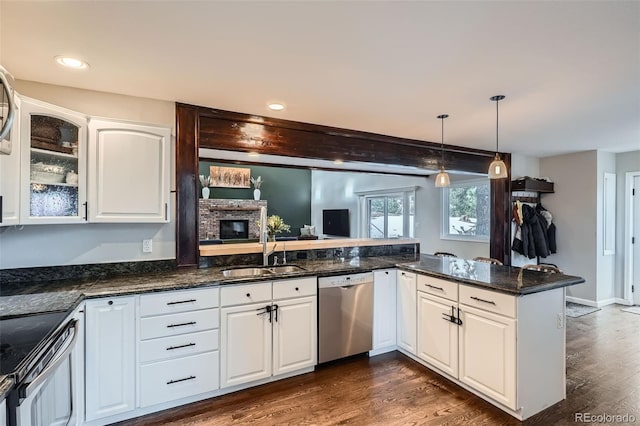 kitchen featuring sink, kitchen peninsula, appliances with stainless steel finishes, and white cabinetry