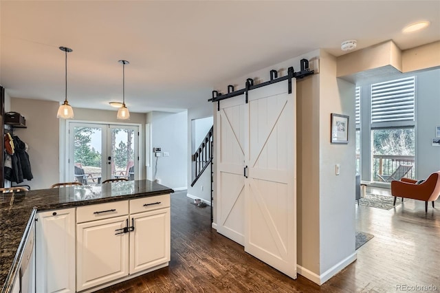 kitchen featuring pendant lighting, white cabinetry, dark hardwood / wood-style flooring, and a barn door