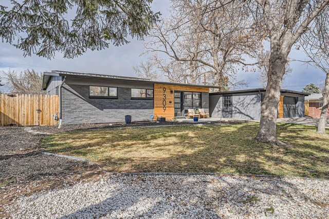 9309 Highland Pl, Arvada, CO 80002 - view of front facade with fence, brick siding, and a front yard