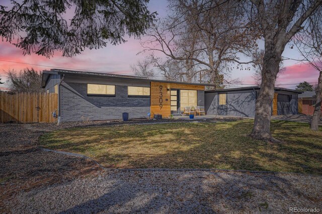 9309 Highland Pl, Arvada, CO 80002 - view of front of property with brick siding, fence, a patio, and a front yard