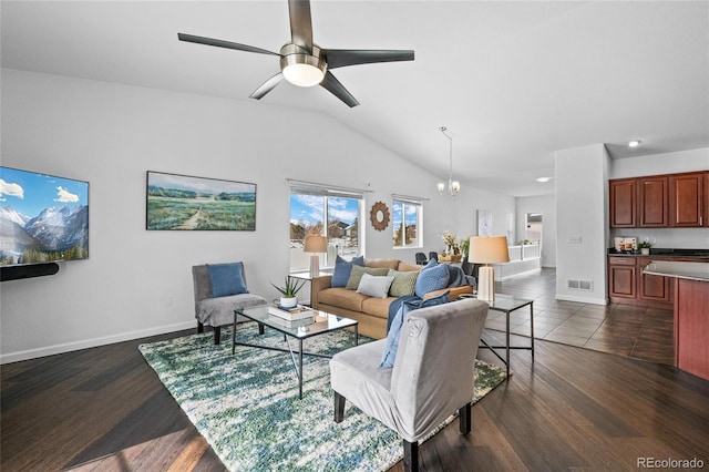 living room with lofted ceiling, dark wood-type flooring, and ceiling fan with notable chandelier