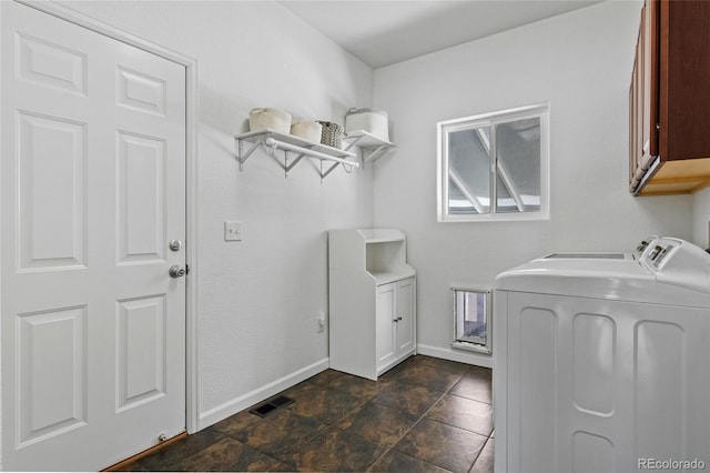 laundry room featuring cabinet space, baseboards, visible vents, washing machine and clothes dryer, and stone finish flooring