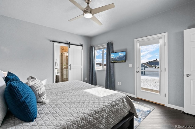 bedroom with access to exterior, hardwood / wood-style flooring, a barn door, and ceiling fan