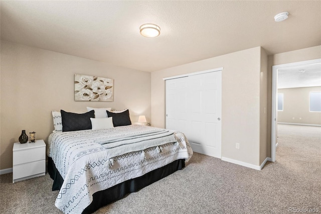 bedroom featuring a closet, carpet flooring, and baseboards