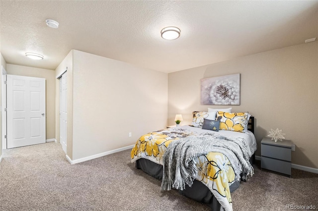 carpeted bedroom featuring baseboards and a textured ceiling