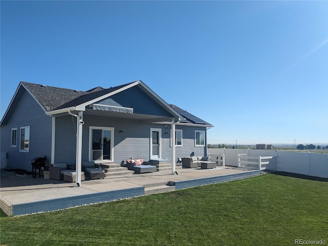 back of house featuring an outdoor living space, a patio, and a yard