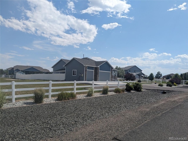 view of front facade featuring concrete driveway, a fenced front yard, and an attached garage