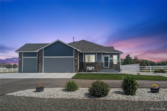 view of front of home featuring driveway, an attached garage, fence, and a shingled roof