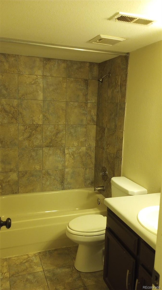 full bathroom featuring vanity, tiled shower / bath combo, toilet, and tile patterned flooring