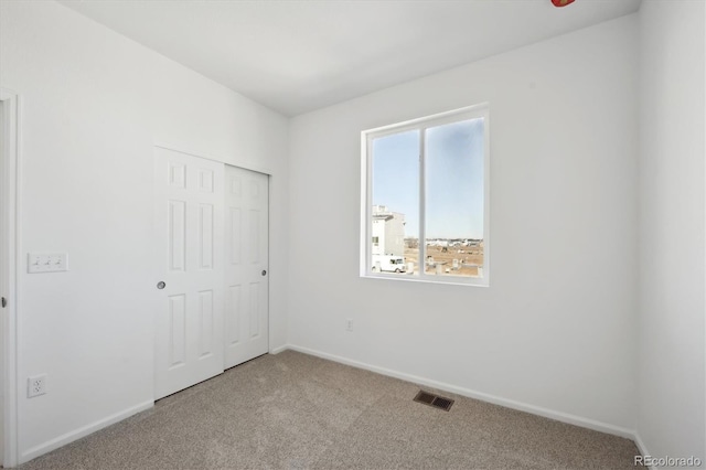 unfurnished bedroom with carpet floors and a closet