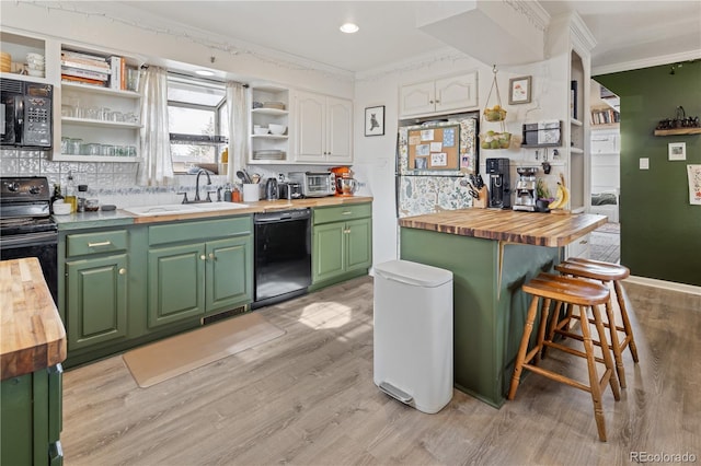 kitchen featuring black appliances, open shelves, wood counters, a sink, and green cabinetry