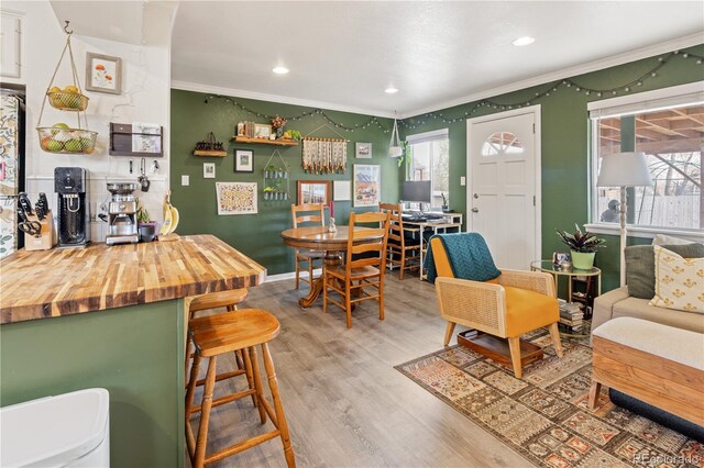 living area with recessed lighting, baseboards, wood finished floors, and ornamental molding