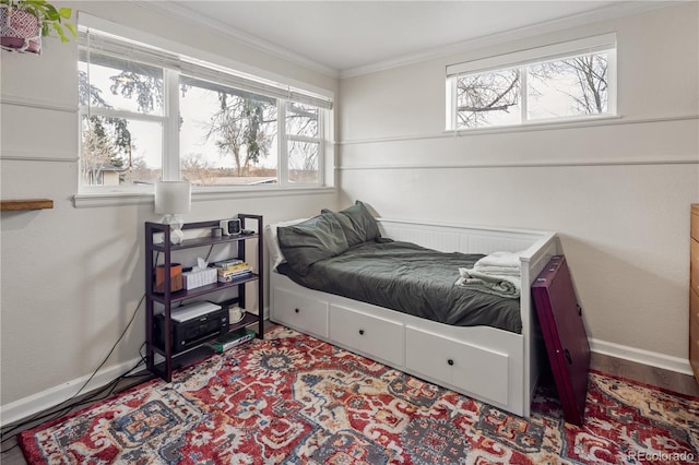 bedroom featuring wood finished floors, baseboards, and ornamental molding