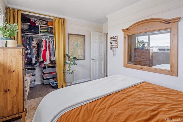 bedroom with crown molding, wood finished floors, and a closet