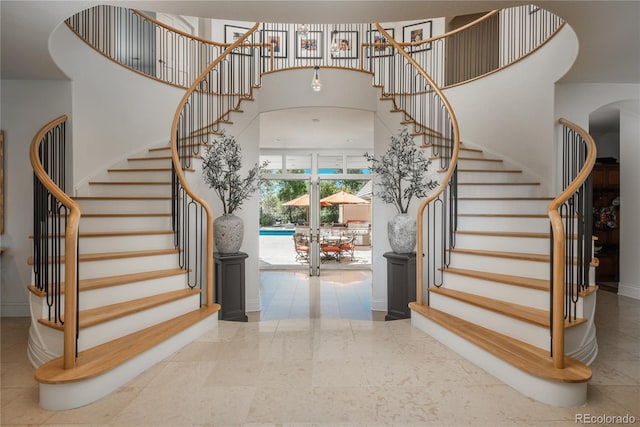 stairway featuring a high ceiling, tile patterned flooring, and french doors