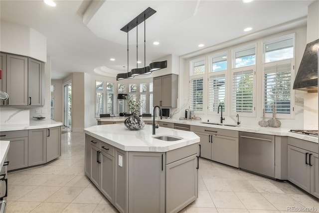 kitchen featuring gray cabinetry, dishwasher, decorative light fixtures, a center island with sink, and sink