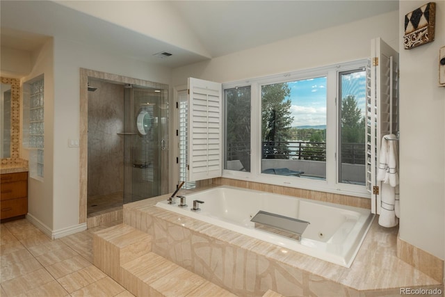 bathroom with independent shower and bath, vanity, lofted ceiling, and tile patterned flooring