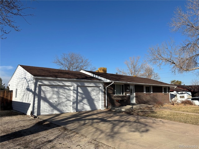 single story home with a garage, concrete driveway, and brick siding