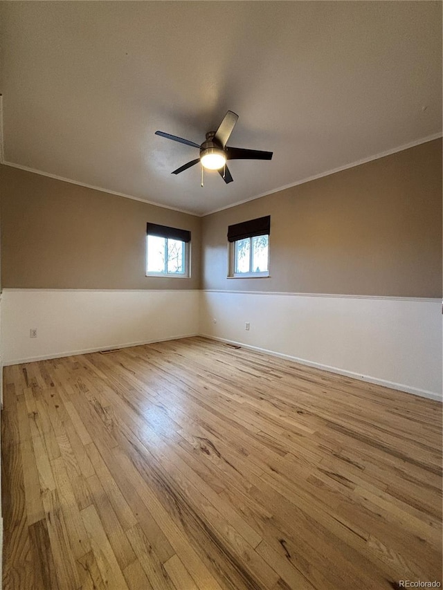 unfurnished room featuring baseboards, a ceiling fan, light wood-style flooring, and crown molding