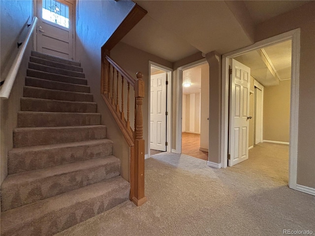 stairway featuring carpet and baseboards