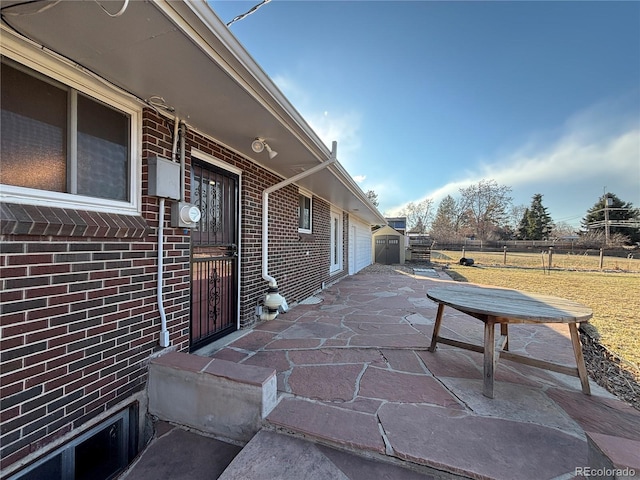 exterior space featuring a yard, brick siding, a patio, and fence