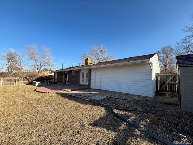 rear view of house featuring french doors, a lawn, a patio area, and fence