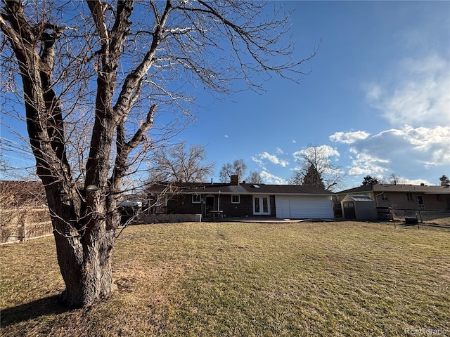 single story home featuring a chimney, french doors, and a front yard