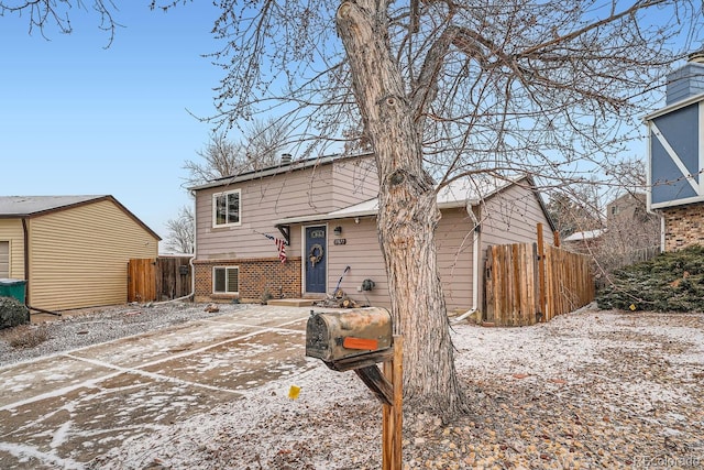 view of front of property with brick siding and fence