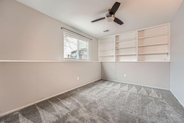 spare room with carpet floors, visible vents, ceiling fan, and baseboards