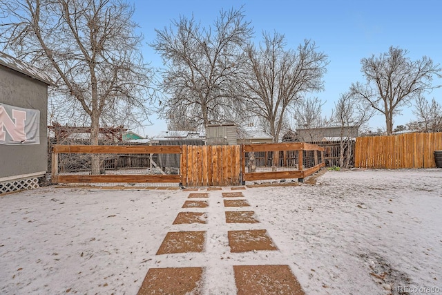 yard covered in snow featuring fence