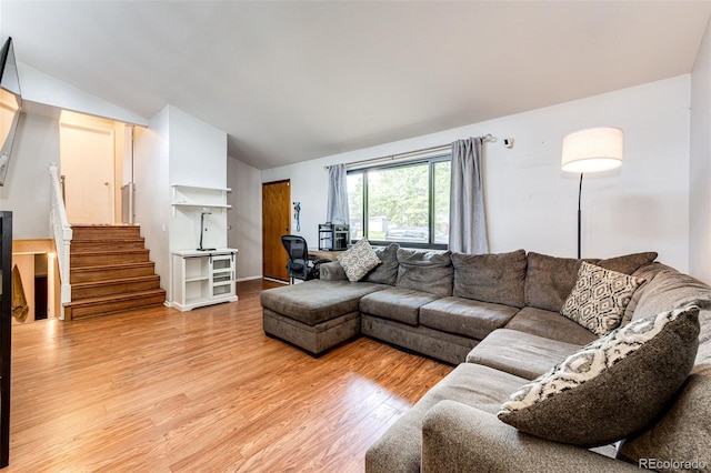 3111 Troy St, Aurora, CO 80011 - living room featuring vaulted ceiling, light wood-style flooring, and stairs