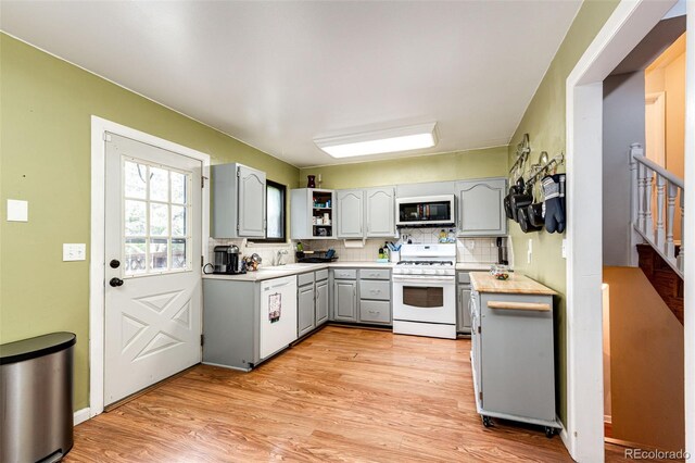 3111 Troy St, Aurora, CO 80011 - kitchen featuring white appliances, gray cabinetry, light wood-style flooring, decorative backsplash, and open shelves