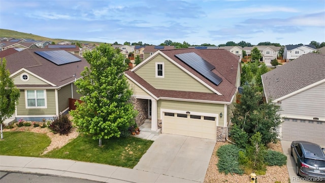 6046 Gilbert Way, Golden, CO 80403 - view of front of house with a residential view, stone siding, driveway, and solar panels
