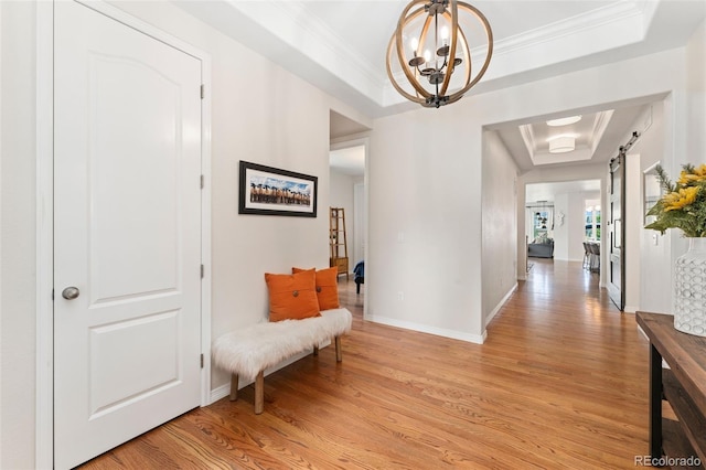 6046 Gilbert Way, Golden, CO 80403 - hallway featuring a tray ceiling, light wood-style floors, crown molding, and a chandelier