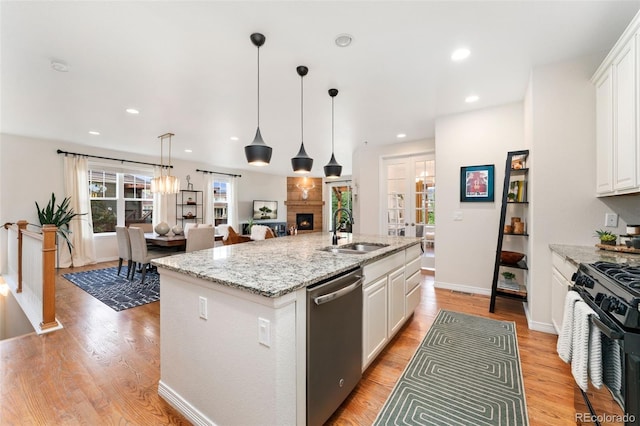 6046 Gilbert Way, Golden, CO 80403 - kitchen featuring dishwasher, black range with gas stovetop, white cabinetry, a center island with sink, and hanging light fixtures
