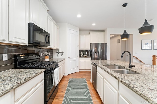 6046 Gilbert Way, Golden, CO 80403 - kitchen with black appliances, light wood-style flooring, white cabinets, hanging light fixtures, and tasteful backsplash