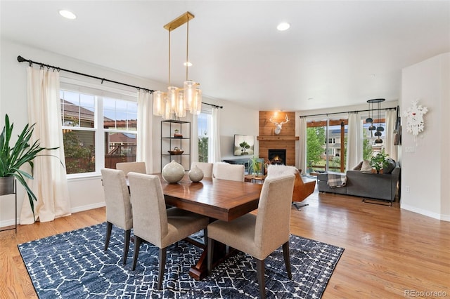 6046 Gilbert Way, Golden, CO 80403 - dining area featuring wood finished floors, a large fireplace, a chandelier, and recessed lighting