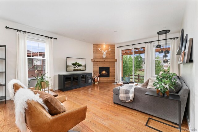 6046 Gilbert Way, Golden, CO 80403 - living room featuring plenty of natural light, wood finished floors, and a large fireplace