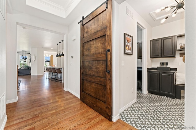 6046 Gilbert Way, Golden, CO 80403 - hallway with light wood-style floors, crown molding, and a barn door